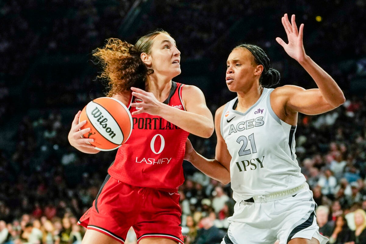 Jul 28, 2026; Las Vegas, Nevada, USA; Portland Fire guard Carla Leite (0) drives the ball against Las Vegas Aces forward-center Brianna Turner (21) during the second quarter of a WNBA basketball game at Michelob Ultra Arena. Mandatory Credit: Lucas Peltier-Imagn Images