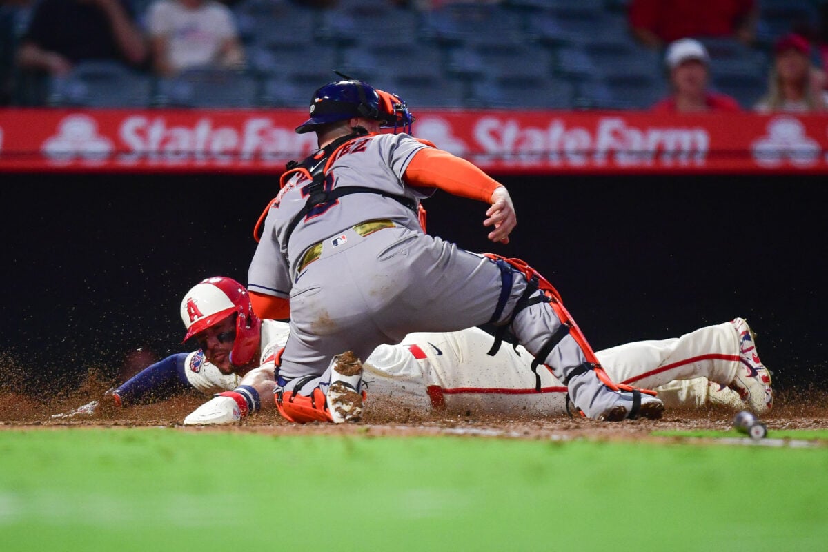 Jul 28, 2026; Anaheim, California, USA; Los Angeles Angels center fielder Mike Trout (27) scores a run against Houston Astros catcher Christian Vazquez (2) during the fifth inning at Angel Stadium. Mandatory Credit: Gary A. Vasquez-Imagn Images