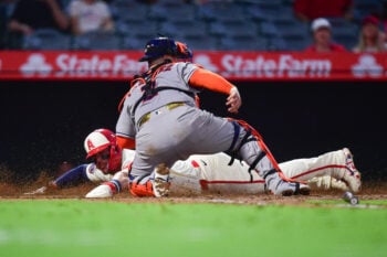 Jul 28, 2026; Anaheim, California, USA; Los Angeles Angels center fielder Mike Trout (27) scores a run against Houston Astros catcher Christian Vazquez (2) during the fifth inning at Angel Stadium. Mandatory Credit: Gary A. Vasquez-Imagn Images