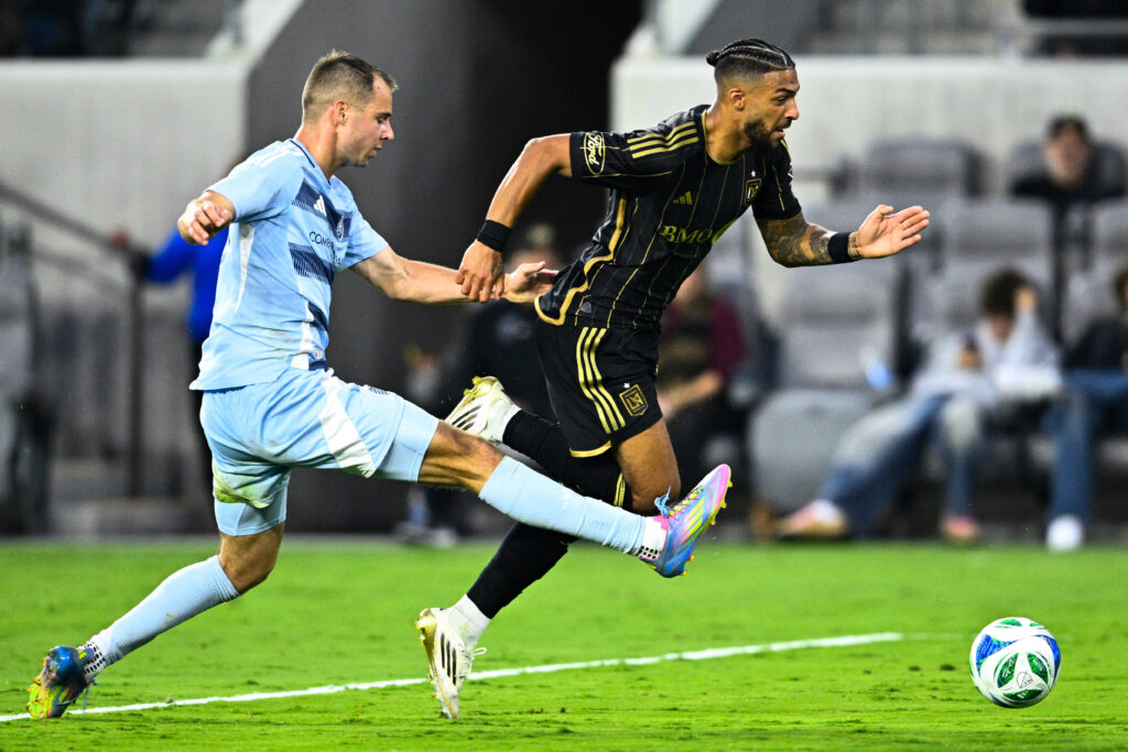Jun 8, 2025; Los Angeles, California, USA; Sporting Kansas City defender Jansen Miller (15) trips up LAFC forward Denis Bouanga (99) during the second half at BMO Stadium. Mandatory Credit: Kelvin Kuo-Imagn Images