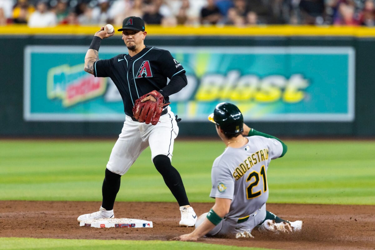 Jul 21, 2026; Phoenix, Arizona, USA; Arizona Diamondbacks second baseman Ildemaro Vargas (left) throws to first base to complete the double play after forcing out sliding Athletics base runner Tyler Soderstrom in the third inning at Chase Field. Mandatory Credit: Mark J. Rebilas-Imagn Images