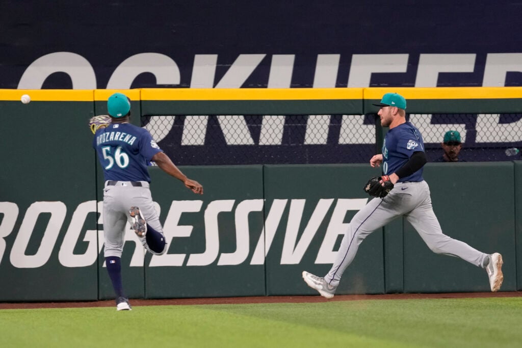 Jul 25, 2026; Arlington, Texas, USA; Seattle Mariners left fielder Randy Arozarena (56) and center fielder Luke Raley (20) chase the double hit by Texas Rangers left fielder Alejandro Osuna (19) during the eighth inning at Globe Life Field. Mandatory Credit: Jim Cowsert-Imagn Images