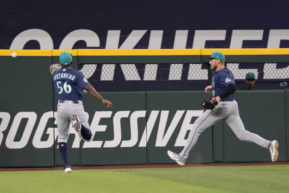 Jul 25, 2026; Arlington, Texas, USA; Seattle Mariners left fielder Randy Arozarena (56) and center fielder Luke Raley (20) chase the double hit by Texas Rangers left fielder Alejandro Osuna (19) during the eighth inning at Globe Life Field. Mandatory Credit: Jim Cowsert-Imagn Images