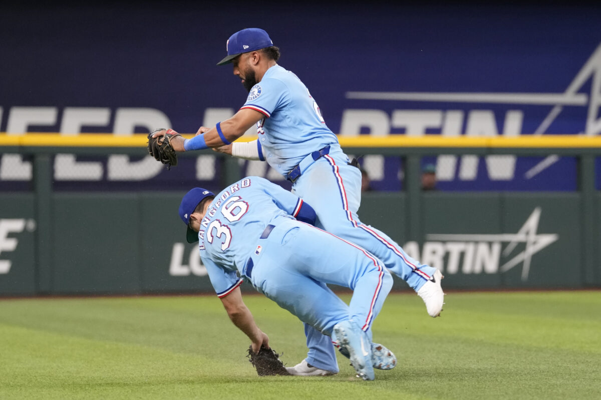 Jul 26, 2026; Arlington, Texas, USA; Texas Rangers shortstop Ezequiel Duran (20) collides into left fielder Wyatt Langford (36) after catching the fly-out hit by Seattle Mariners second baseman Cole Young (2) during the eighth inning at Globe Life Field. Mandatory Credit: Jim Cowsert-Imagn Images
