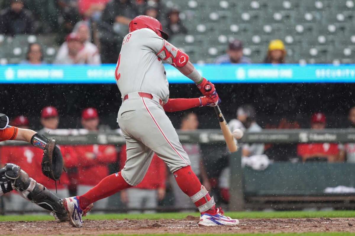 Aug 2, 2026; Baltimore, Maryland, USA; Philadelphia Phillies designated hitter Kyle Schwarber (12) hits a sacrifice fly ball against the Baltimore Orioles during the fifth inning at Oriole Park at Camden Yards. Mandatory Credit: Gregory Fisher-Imagn Images