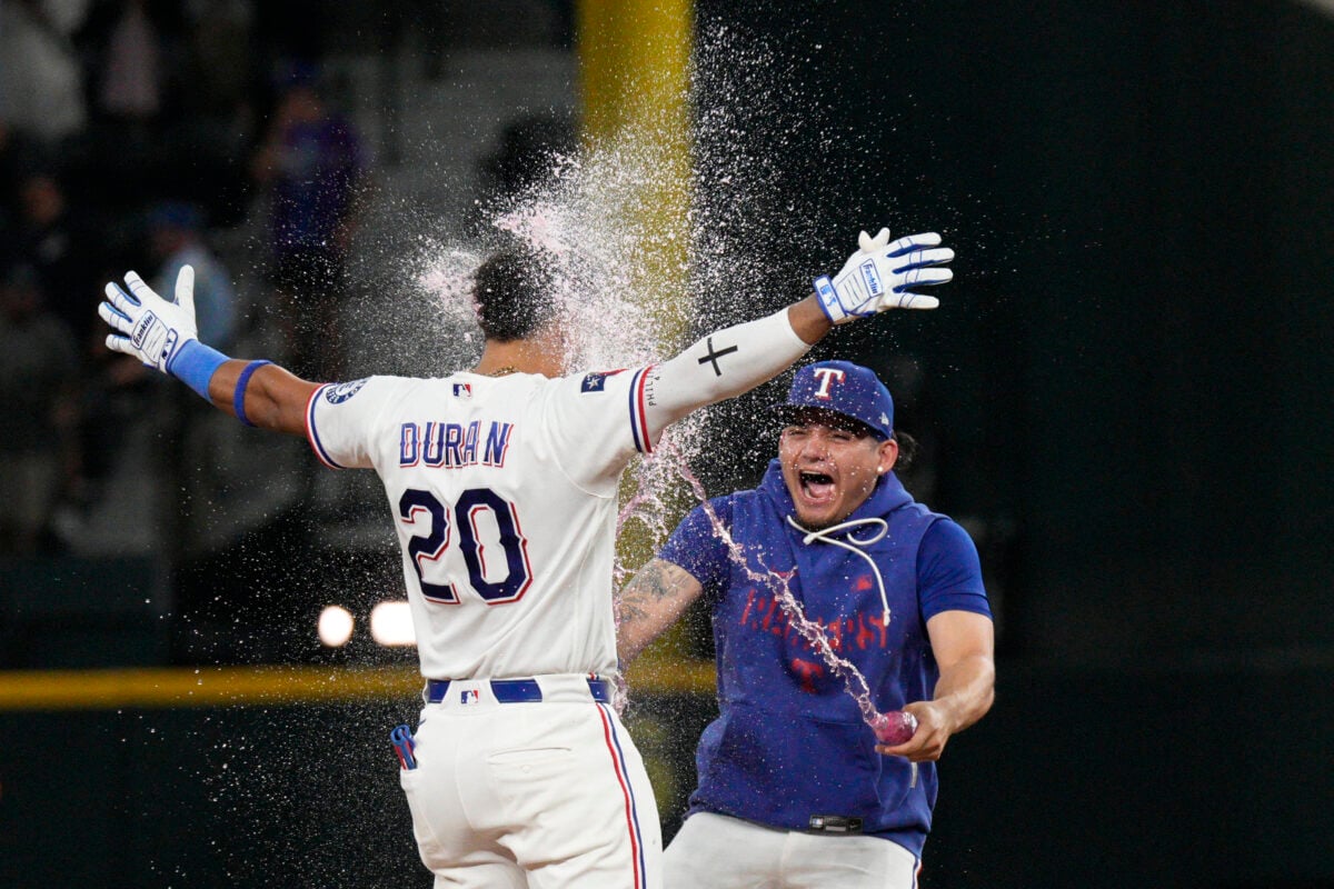 Aug 4, 2026; Arlington, Texas, USA; Texas Rangers shortstop Ezequiel Duran (20) is doused by left fielder Alejandro Osuna (19) after hitting a walk-off RBI double against the San Francisco Giants during the ninth inning at Globe Life Field. Mandatory Credit: Raymond Carlin III-Imagn Images