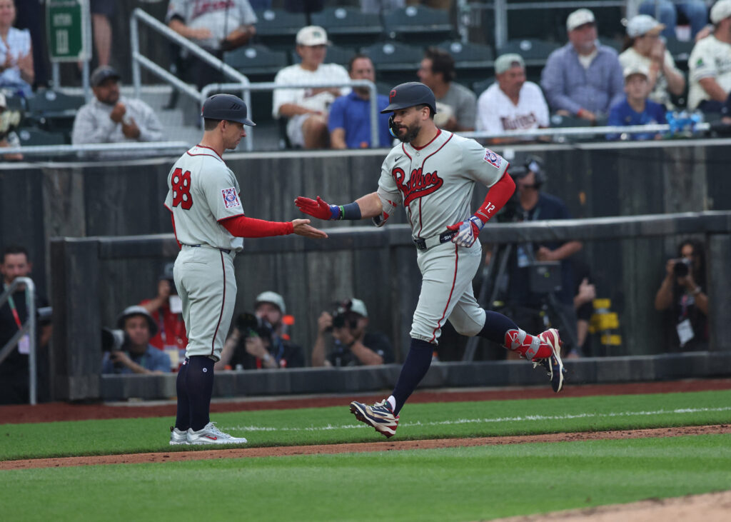 Aug 13, 2026; Dyersville, Iowa, USA; Philadelphia Phillies designated hitter Kyle Schwarber (12) celebrates with Philadelphia Phillies third base coach Anthony Contreras (88) after hitting his second home run against the Minnesota Twins at the Field of Dreams. Mandatory Credit: Reese Strickland-Imagn Images