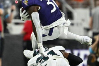 Aug 15, 2026; Baltimore, Maryland, USA;  Baltimore Ravens running back Dontae McMillan (36) leaps over Philadelphia Eagles safety Andre' Sam (31) in the second quarter at M&T Bank Stadium. Mandatory Credit: Jamie Sabau-Imagn Images