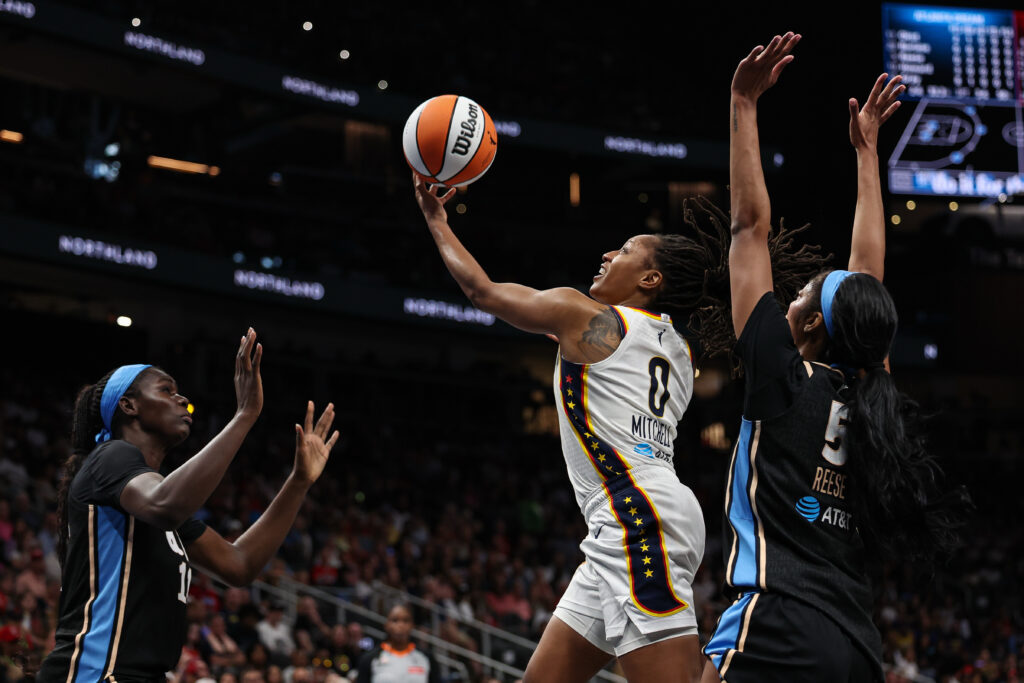 Aug 16, 2026; Atlanta, Georgia, USA; Indiana Fever guard Kelsey Mitchell (0) shoots against Atlanta Dream forward Angel Reese (5) during the first quarter at State Farm Arena. Mandatory Credit: Colin Hubbard-Imagn Images