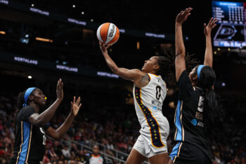 Aug 16, 2026; Atlanta, Georgia, USA; Indiana Fever guard Kelsey Mitchell (0) shoots against Atlanta Dream forward Angel Reese (5) during the first quarter at State Farm Arena. Mandatory Credit: Colin Hubbard-Imagn Images