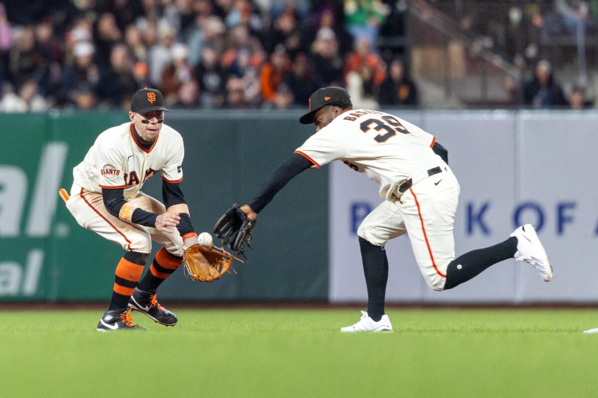 Aug 24, 2026; San Francisco, California, USA;  San Francisco Giants third baseman Christian Koss (50) and second baseman Osleivis Basabe (39) both reach for a ball during the sixth inning against the Cincinnati Reds at Oracle Park.  Mandatory Credit: Bob Kupbens-Imagn Images