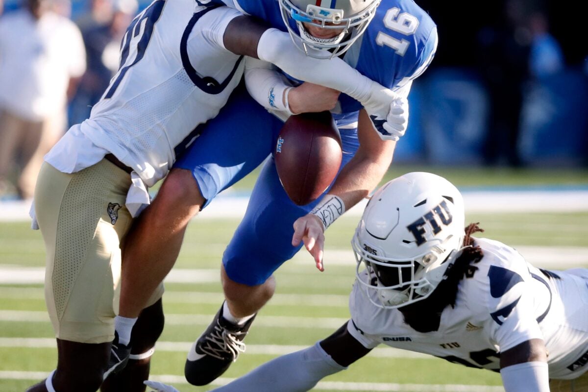 Middle Tennessee quarterback Roman Gagliano (16) fumbles the ball as he runs between FIU defensive back Mister Clark (27) and FIU defensive back Jessiah McGrew (23) during the college football game at MTSU, on Saturday, Nov. 8, 2025. The ball was fumble was recovered by Middle Tennessee.