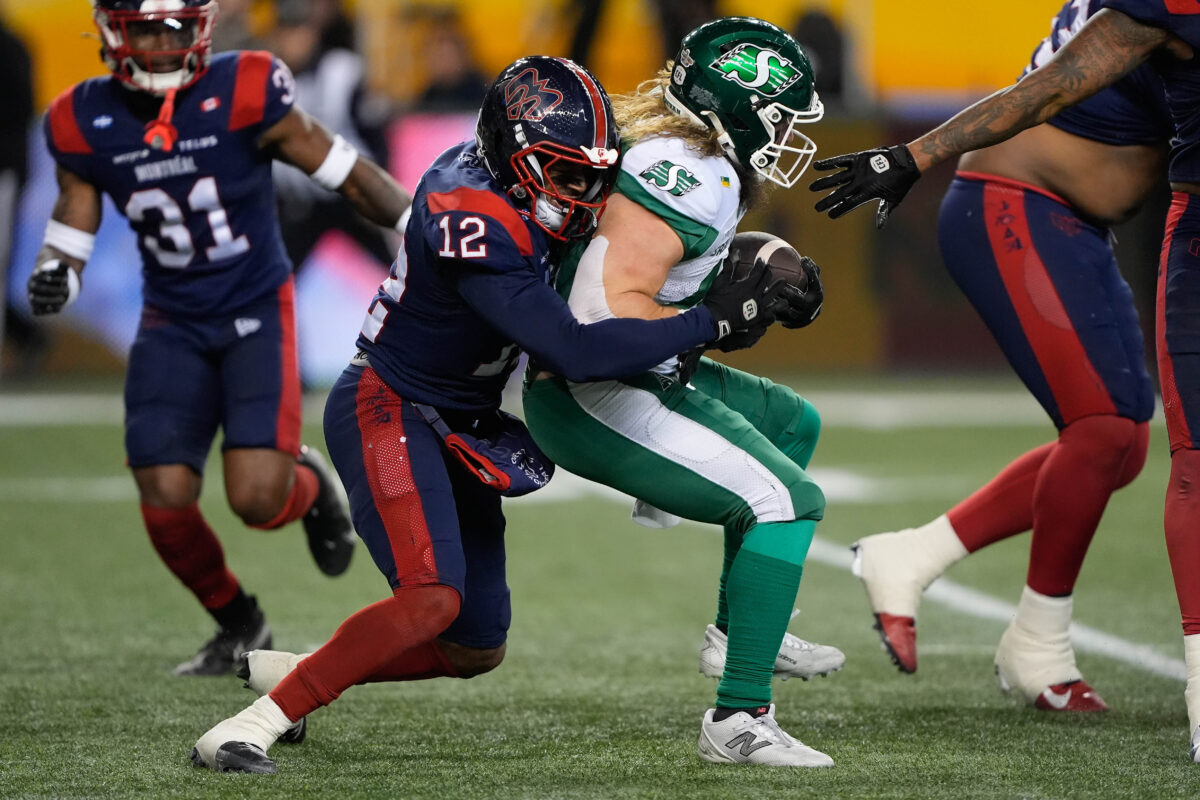 Nov 16, 2025; Winnipeg, Manitoba, Canada; Montreal Alouettes defensive back Najee Murray (12) tackles Saskatchewan Roughriders running back A.J. Ouellette (45) on a rushing play during the 112th Grey Cup Championship at Princess Auto Stadium. Mandatory Credit: John E. Sokolowski-Imagn Images