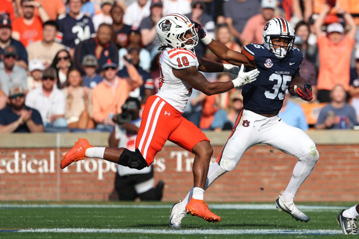 Nov 22, 2025; Auburn, Alabama, USA;  Auburn Tigers running back Justin Jones (35) stiff arms Mercer Bears linebacker Julian Fox (10) during the second quarter at Jordan-Hare Stadium. Mandatory Credit: John Reed-Imagn Images