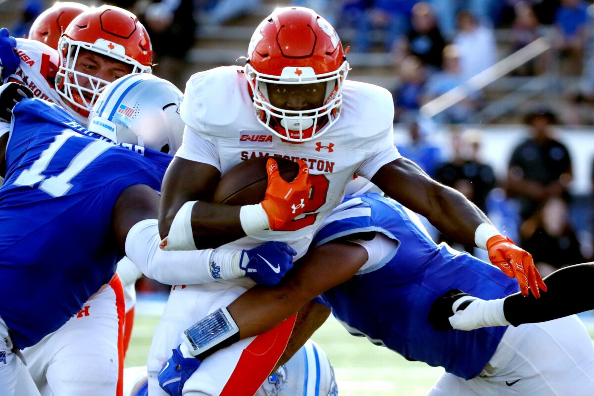 Sam Houston running back Alton McCaskill (22) carries the ball as Middle Tennessee linebacker Brandon Buckner (11) and Middle Tennessee defensive end Anthony Bynum (0) make the stop during the NCAA college football game on Saturday, Nov. 22, 2025, at Middle Tennessee.