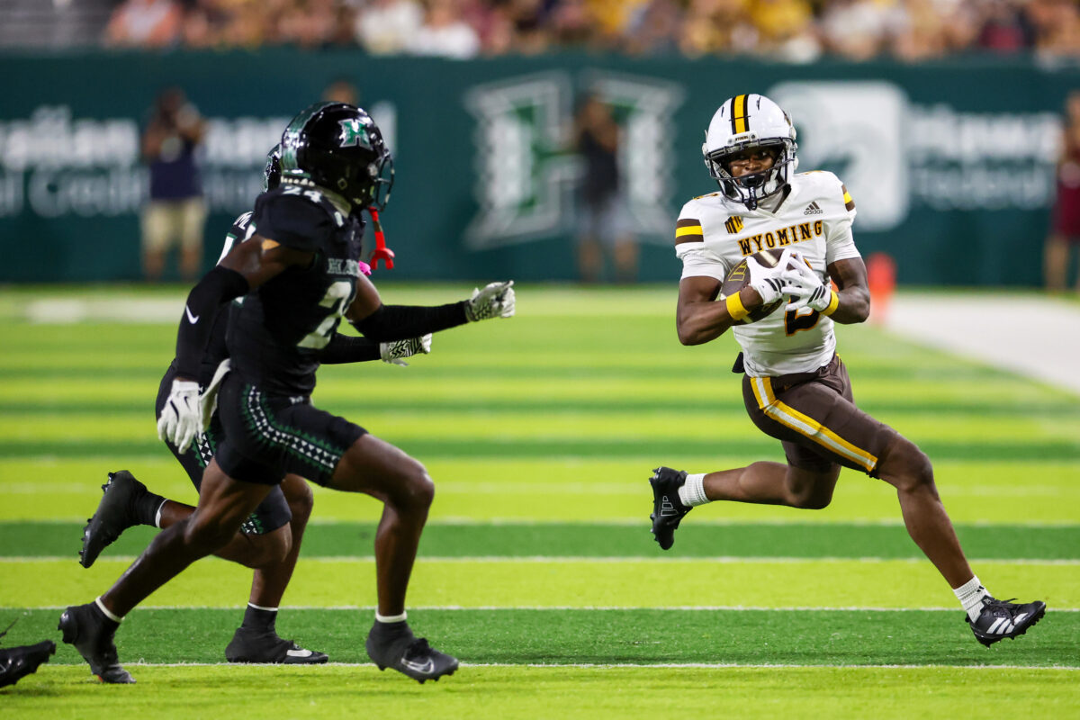 Nov 29, 2025; Honolulu, Hawaii, USA; Wyoming Cowboys wide receiver Eric Richardson (2) runs after the catch against Hawaii Rainbow Warriors defensive backs Devyn King (24) and Elijah Palmer (4) (obscured) during the third quarter at Clarence T.C. Ching Athletics Complex. Mandatory Credit: Marco Garcia-Imagn Images