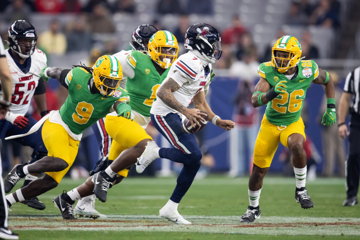 Jan 1, 2024; Glendale, AZ, USA; Liberty Flames quarterback Kaidon Salter (7) against Oregon Ducks linebacker Devon Jackson (26) in the 2024 Fiesta Bowl at State Farm Stadium. Mandatory Credit: Mark J. Rebilas-USA TODAY Sports