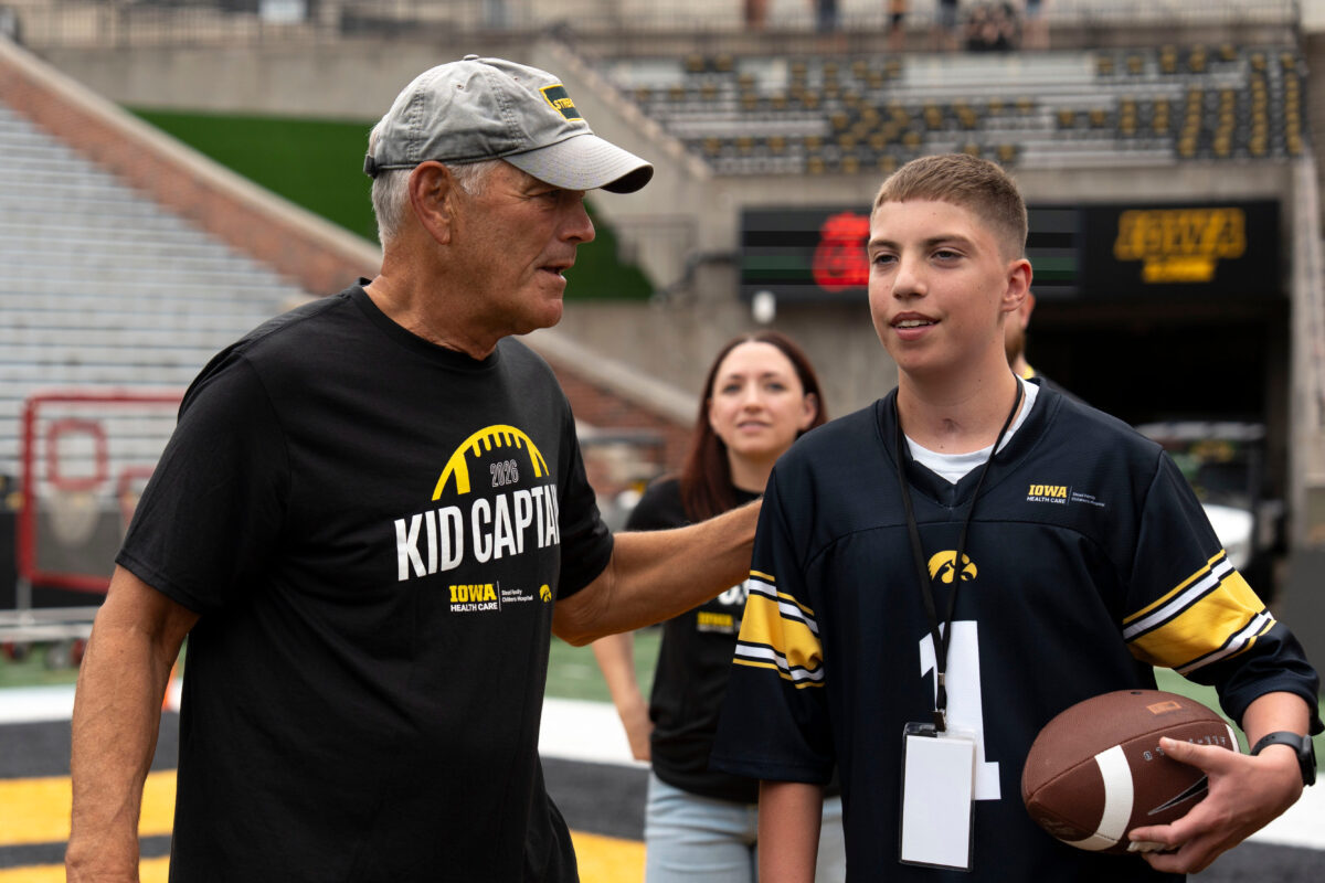 Iowa head coach Kirk Ferentz talks to Kid Captain Beau Harvey Aug. 15, 2026 during the Kids Day at Kinnick open practice at Kinnick Stadium in Iowa City, Iowa.