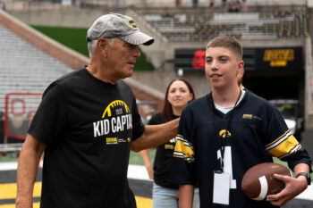 Iowa head coach Kirk Ferentz talks to Kid Captain Beau Harvey Aug. 15, 2026 during the Kids Day at Kinnick open practice at Kinnick Stadium in Iowa City, Iowa.