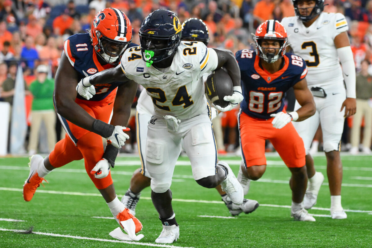 Sep 12, 2026; Syracuse, New York, USA;  California Golden Bears running back Adam Mohammed (24) runs with the ball past Syracuse Orange defensive lineman Nissi Ogbebor (11) during the second half at the JMA Wireless Dome.  Mandatory Credit: Rich Barnes-Imagn Images