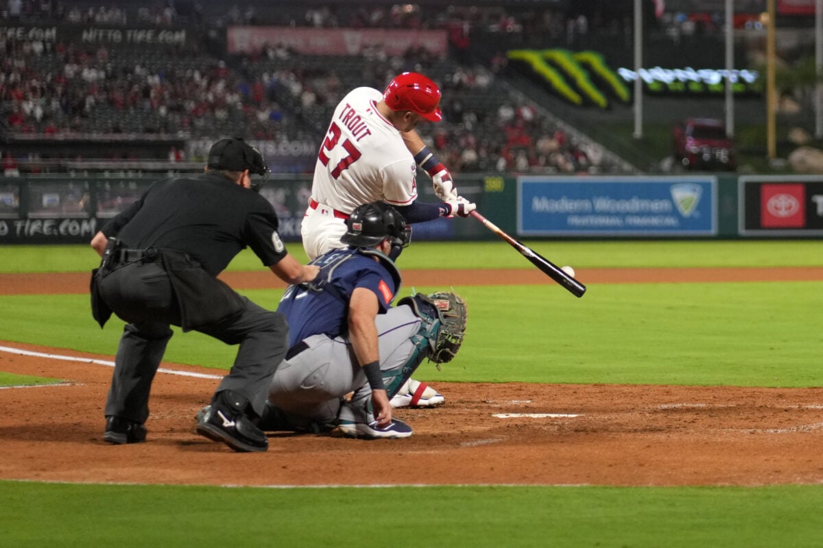 Sep 14, 2026; Anaheim, California, USA; Los Angeles Angels designated hitter Mike Trout (27) bats in the fifth inning as Seattle Mariners catcher Cal Raleigh (29) and home plate umpire Chad Whitson watch at Angel Stadium. Mandatory Credit: Kirby Lee-Imagn Images