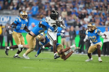 Sep 19, 2026; Pasadena, California, USA; Purdue Boilermakers running back Fame Ijeboi (2) carries the ball against UCLA Bruins linebacker Scott Taylor (20), defensive back Malik Hartford (12) and defensive back Ty Lee (22) in the first half at the Rose Bowl. Mandatory Credit: Kirby Lee-Imagn Images