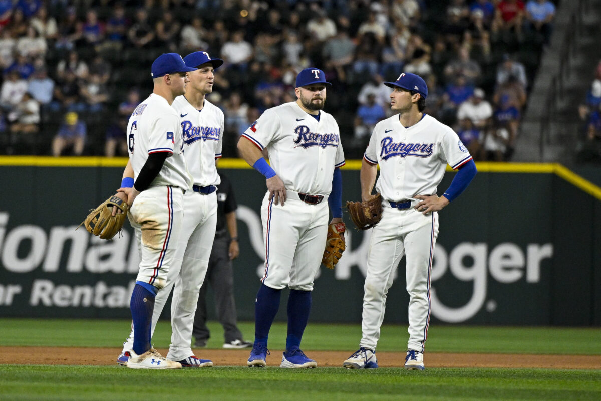 Sep 22, 2026; Arlington, Texas, USA; Texas Rangers third baseman Josh Jung (6) and shortstop Corey Seager (5) and first baseman Jake Burger (21) and second baseman Justin Foscue (14) look on during the seventh inning against the New York Mets at Globe Life Field. Mandatory Credit: Jerome Miron-Imagn Images