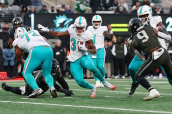 Dec 7, 2025; East Rutherford, New Jersey, USA; Miami Dolphins running back Ollie Gordon II (31) runs with the ball for a touchdown against the New York Jets during the second half at MetLife Stadium. Mandatory Credit: Ed Mulholland-Imagn Images