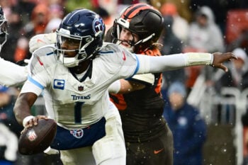 Dec 7, 2025; Cleveland, Ohio, USA; Tennessee Titans quarterback Cam Ward (1) scrambles from Cleveland Browns linebacker Carson Schwesinger (49) during the third quarter at Huntington Bank Field. Mandatory Credit: Ken Blaze-Imagn Images