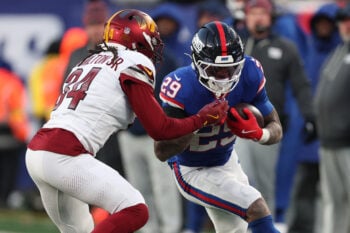 Dec 14, 2025; East Rutherford, New Jersey, USA;  New York Giants running back Tyrone Tracy Jr. (29) runs the ball against Washington Commanders cornerback Antonio Hamilton Sr. (34) during the fourth quarter at MetLife Stadium. Mandatory Credit: Vincent Carchietta-Imagn Images