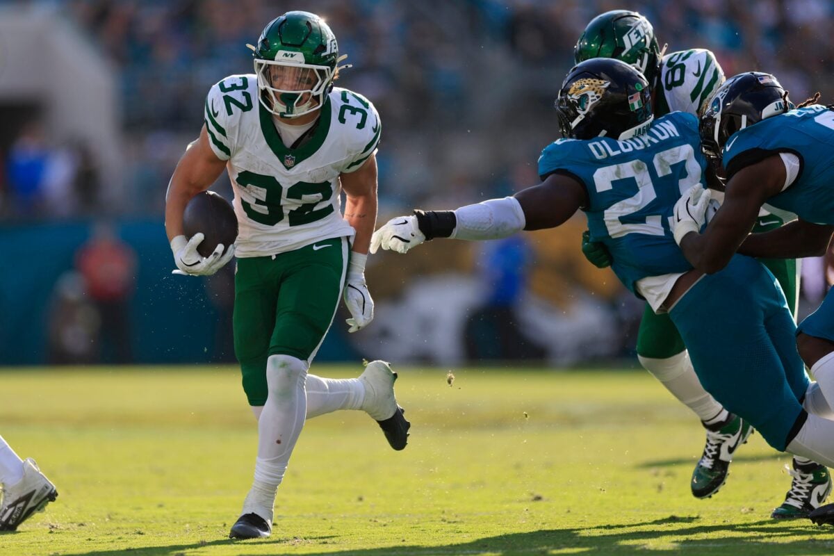 New York Jets running back Isaiah Davis (32) rushes for yards en route to a touchdown score against Jacksonville Jaguars linebacker Foyesade Oluokun (23) during the fourth quarter of an NFL football matchup at EverBank Stadium, Sunday, Dec. 14, 2025, in Jacksonville, Fla. The Jaguars defeated the Jets 48-20. [Corey Perrine/Florida Times-Union]