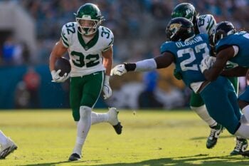 New York Jets running back Isaiah Davis (32) rushes for yards en route to a touchdown score against Jacksonville Jaguars linebacker Foyesade Oluokun (23) during the fourth quarter of an NFL football matchup at EverBank Stadium, Sunday, Dec. 14, 2025, in Jacksonville, Fla. The Jaguars defeated the Jets 48-20. [Corey Perrine/Florida Times-Union]