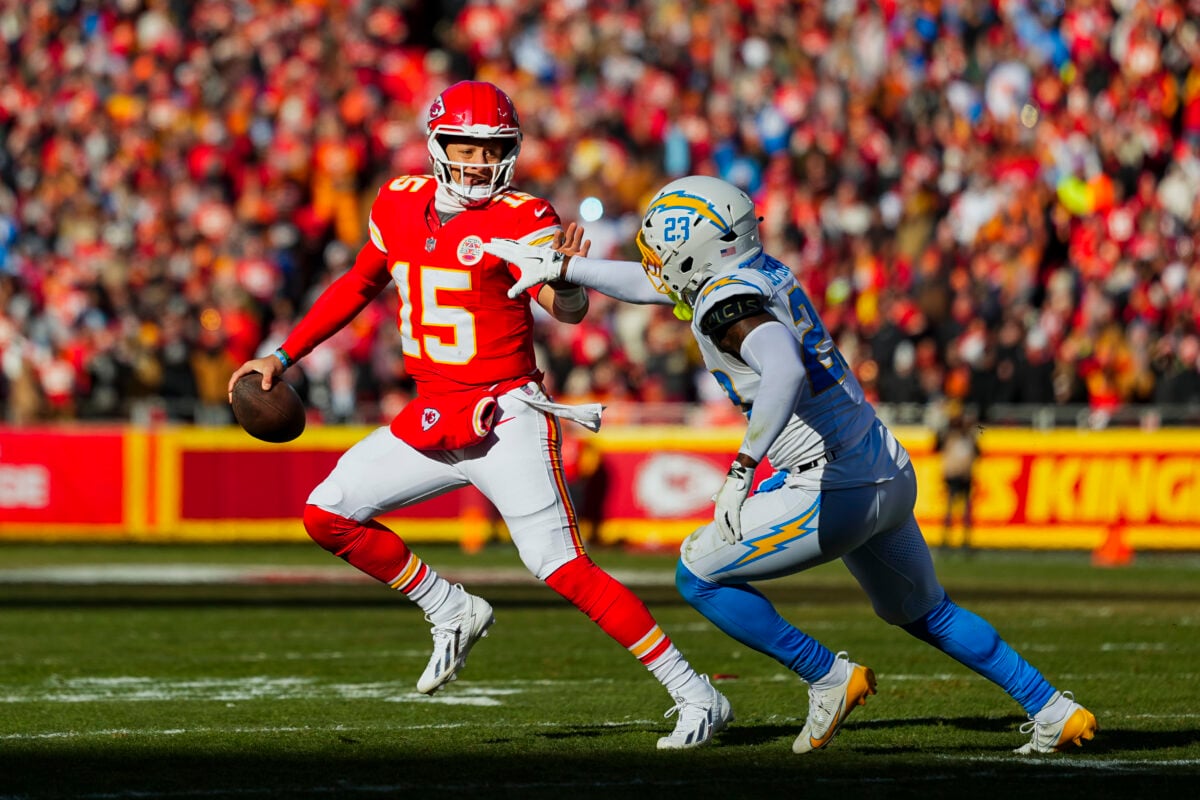Dec 14, 2025; Kansas City, Missouri, USA; Kansas City Chiefs quarterback Patrick Mahomes (15) scrambles against Los Angeles Chargers safety Tony Jefferson (23) during the first half at GEHA Field at Arrowhead Stadium. Mandatory Credit: Jay Biggerstaff-Imagn Images