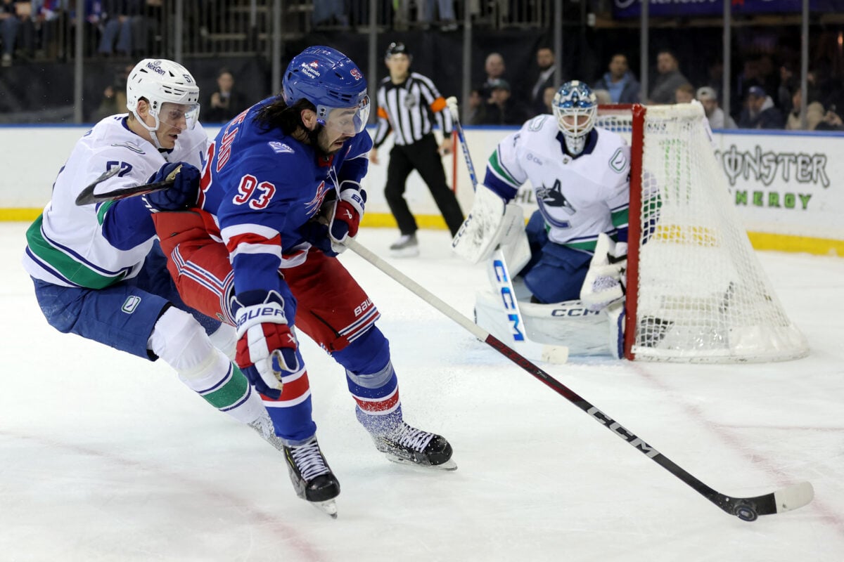 Dec 16, 2025; New York, New York, USA; New York Rangers center Mika Zibanejad (93) plays the puck against Vancouver Canucks defenseman Tyler Myers (57) during the second period at Madison Square Garden. Mandatory Credit: Brad Penner-Imagn Images