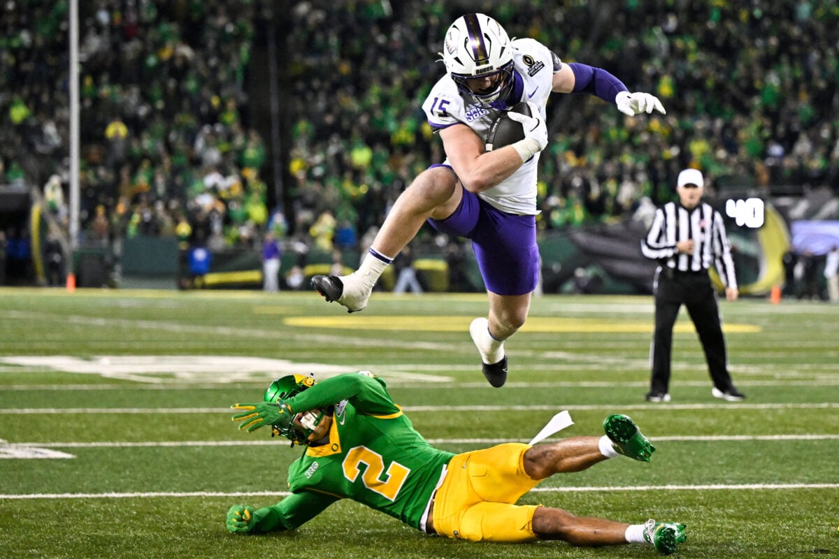 Dec 20, 2025; Eugene, OR, USA; James Madison Dukes tight end Lacota Dippre (15) hurdles over Oregon Ducks defensive back Kingston Lopa (2) to score a touchdown during the fourth quarter at Autzen Stadium. Mandatory Credit: Craig Strobeck-Imagn Images