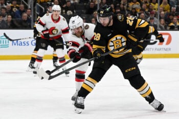 Dec 21, 2025; Boston, Massachusetts, USA; Boston Bruins center Elias Lindholm #28 and Ottawa Senators right wing Claude Giroux #28 battle for the puck during the third period at the TD Garden. Mandatory Credit: Brian Fluharty-Imagn Images