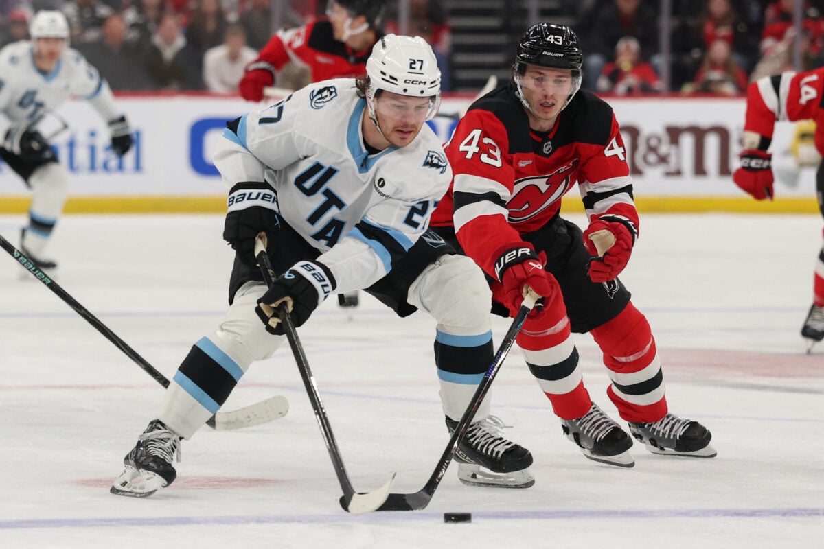Jan 3, 2026; Newark, New Jersey, USA; Utah Mammoth center Barrett Hayton (27) skates with the puck as New Jersey Devils defenseman Luke Hughes (43) during the first period at Prudential Center. Mandatory Credit: Ed Mulholland-Imagn Images