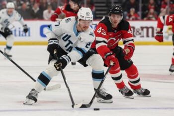Jan 3, 2026; Newark, New Jersey, USA; Utah Mammoth center Barrett Hayton (27) skates with the puck as New Jersey Devils defenseman Luke Hughes (43) during the first period at Prudential Center. Mandatory Credit: Ed Mulholland-Imagn Images