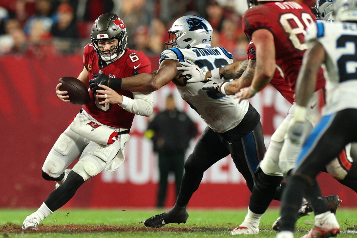Jan 3, 2026; Tampa, Florida, USA; Tampa Bay Buccaneers quarterback Baker Mayfield (6) runs against Carolina Panthers linebacker D.J. Wonnum (98) in the second half at Raymond James Stadium. Mandatory Credit: Nathan Ray Seebeck-Imagn Images