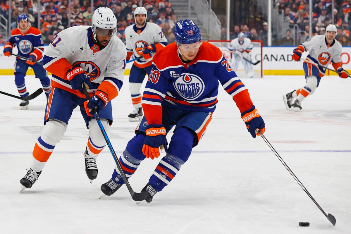 Jan 15, 2026; Edmonton, Alberta, CAN; Edmonton Oilers forward Curtis Lazar (20) protects the puck from New York Islanders forward Anthony Duclair (11) during the second period at Rogers Place. Mandatory Credit: Perry Nelson-Imagn Images