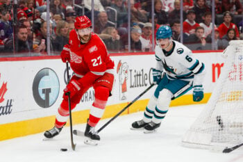 Jan 16, 2026; Detroit, Michigan, USA; Detroit Red Wings center Michael Rasmussen (27) handles the puck against San Jose Sharks defenseman Sam Dickinson (6) during the second period at Little Caesars Arena. Mandatory Credit: Brian Bradshaw Sevald-Imagn Images