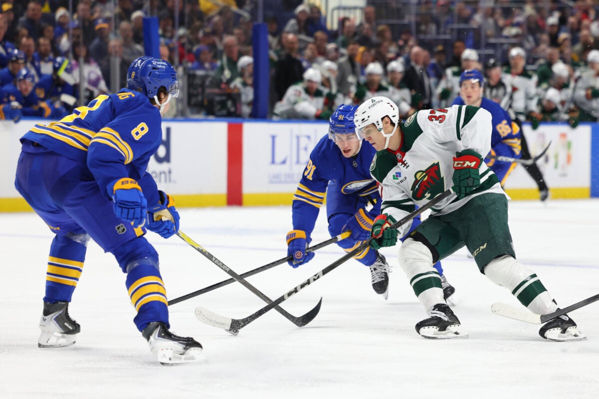 Jan 17, 2026; Buffalo, New York, USA; Minnesota Wild center Hunter Haight (37) skates with the puck as Buffalo Sabres defenseman Michael Kesselring (8) defends during the third period at KeyBank Center. Mandatory Credit: Timothy T. Ludwig-Imagn Images