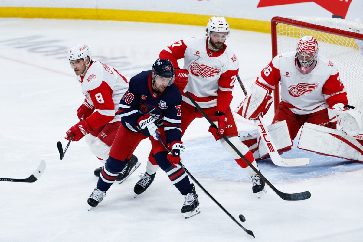 Jan 24, 2026; Winnipeg, Manitoba, CAN; Winnipeg Jets forward Tanner Pearson (70) tries to handle the puck in front of Detroit Red Wings forward Michael Rasmussen (27) during the second period at Canada Life Centre. Mandatory Credit: Terrence Lee-Imagn Images