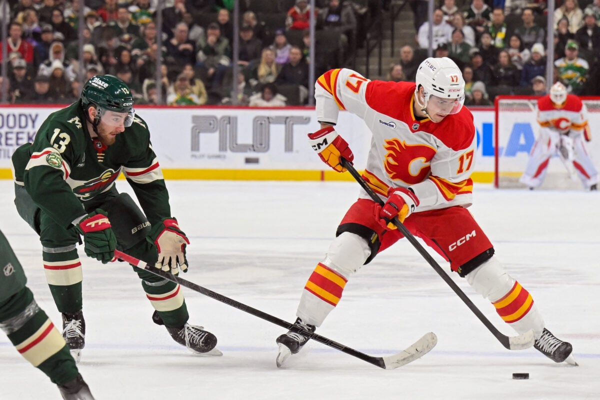 Jan 29, 2026; Saint Paul, Minnesota, USA; Calgary Flames forward Yegor Sharangovich (17) controls the puck as Minnesota Wild forward Yakov Trenin (13) back checks during the first period at Grand Casino Arena. Mandatory Credit: Nick Wosika-Imagn Images