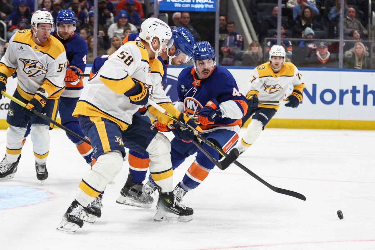 Jan 31, 2026; Elmont, New York, USA; Nashville Predators left wing Michael Bunting (58) battles for control of the puck with New York Islanders defenseman Scott Mayfield (24) and center Jean-Gabriel Pageau (44) in the third period at UBS Arena. Mandatory Credit: Wendell Cruz-Imagn Images
