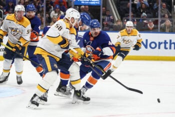 Jan 31, 2026; Elmont, New York, USA;  Nashville Predators left wing Michael Bunting (58) battles for control of the puck with New York Islanders defenseman Scott Mayfield (24) and center Jean-Gabriel Pageau (44) in the third period at UBS Arena. Mandatory Credit: Wendell Cruz-Imagn Images