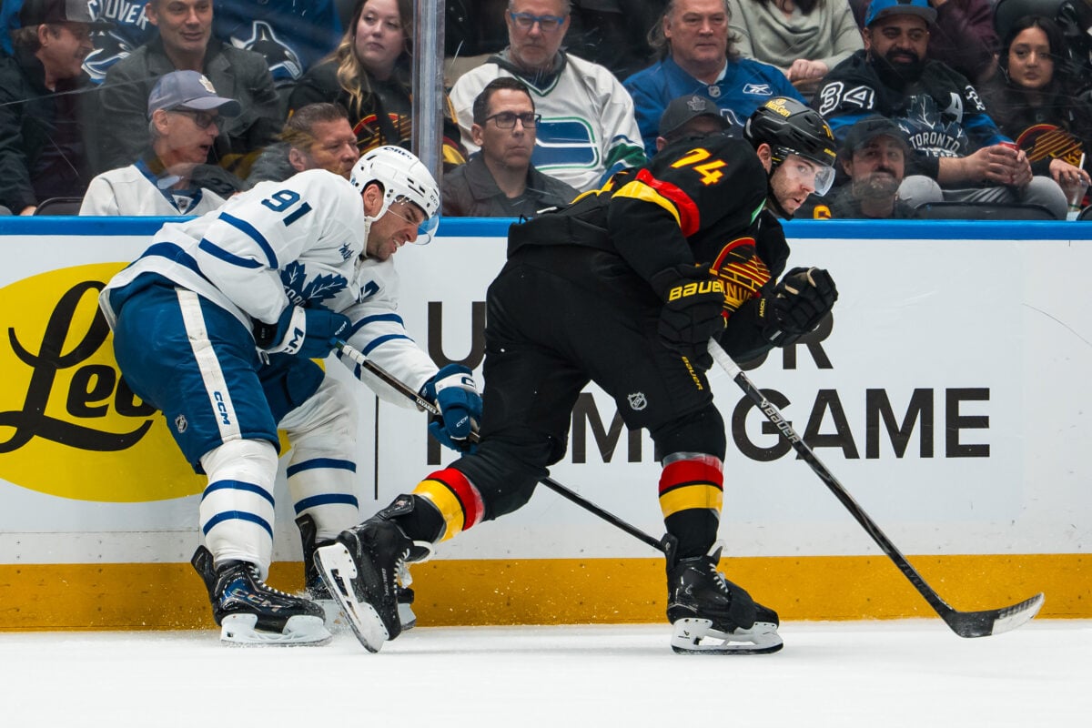 Jan 31, 2026; Vancouver, British Columbia, CAN; Vancouver Canucks forward Jake DeBrusk (74) checks Toronto Maple Leafs forward John Tavares (91) in the third period at Rogers Arena. Mandatory Credit: Bob Frid-Imagn Images