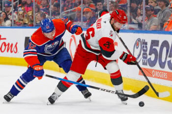 Mar 6, 2026; Edmonton, Alberta, CAN; Carolina Hurricanes defensemen Sean Walker (26) looks to make a pass in front of Edmonton Oilers forward Vasily Podkolzin (92) during the third period at Rogers Place. Mandatory Credit: Perry Nelson-Imagn Images
