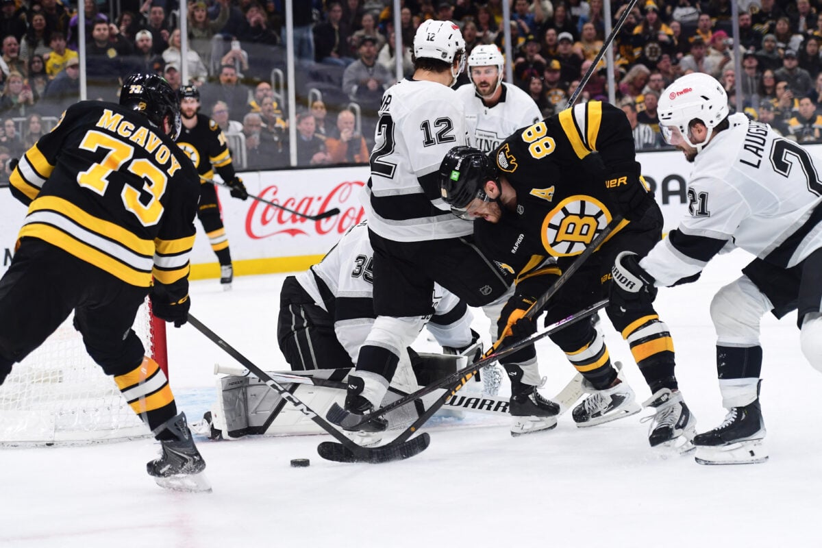 Mar 10, 2026; Boston, Massachusetts, USA;  Boston Bruins defenseman Charlie McAvoy (73) and right wing David Pastrnak (88) battle for the puck with Los Angeles Kings center Scott Laughton (21) during the third period at TD Garden. Mandatory Credit: Bob DeChiara-Imagn Images