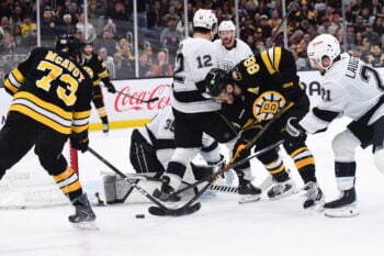 Mar 10, 2026; Boston, Massachusetts, USA;  Boston Bruins defenseman Charlie McAvoy (73) and right wing David Pastrnak (88) battle for the puck with Los Angeles Kings center Scott Laughton (21) during the third period at TD Garden. Mandatory Credit: Bob DeChiara-Imagn Images